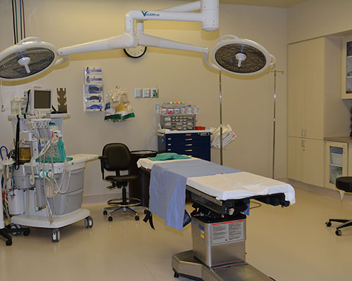 Surgical room with operating table and equipment.