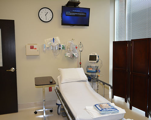 Hospital room with empty patient bed.