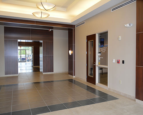 Lobby with wood paneling and tiled floor.