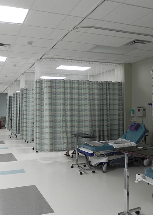 Hospital ward with curtained beds.