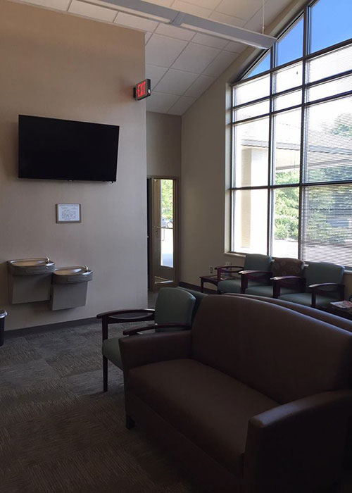 Waiting room with couches and water fountain.