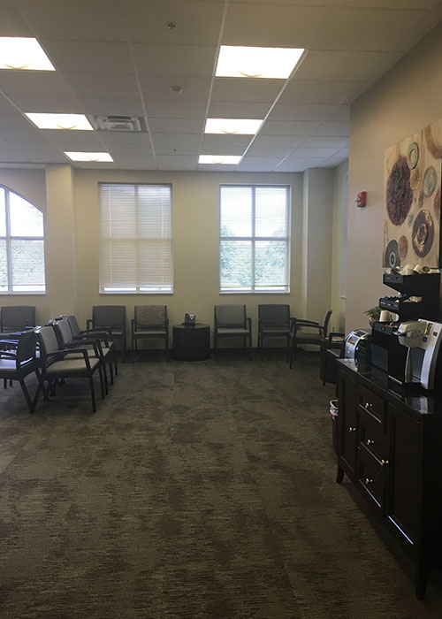 Waiting room with chairs and coffee station.