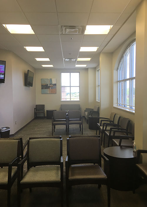 Waiting room with chairs and large windows.