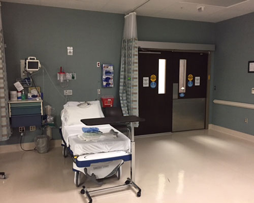 Hospital room with empty patient bed.